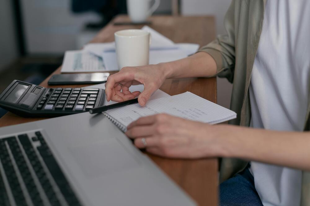 Devis architecte à Paris pour estimer une rénovation, documents et calculatrice sur table